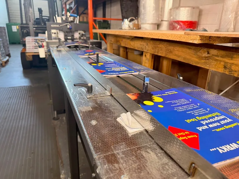 Printed inserts moving along the collating conveyor ahead of wrapping
